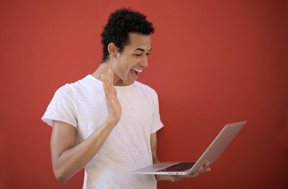 An image showing a person laughing at a computer screen with various cybersecurity-related memes displayed on it.